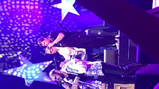 Billy Amendola performing on stage with star lights